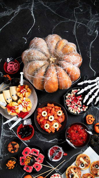 istock Halloween sweets for Halloween party on black background. top view 1582088410