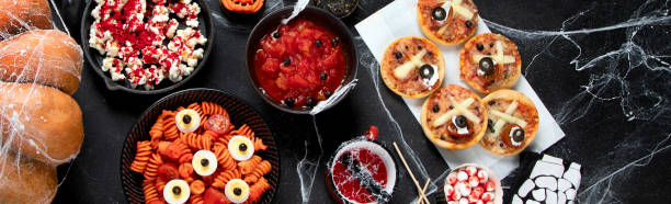 istock Halloween sweets for Halloween party on black background. top view 1582091078