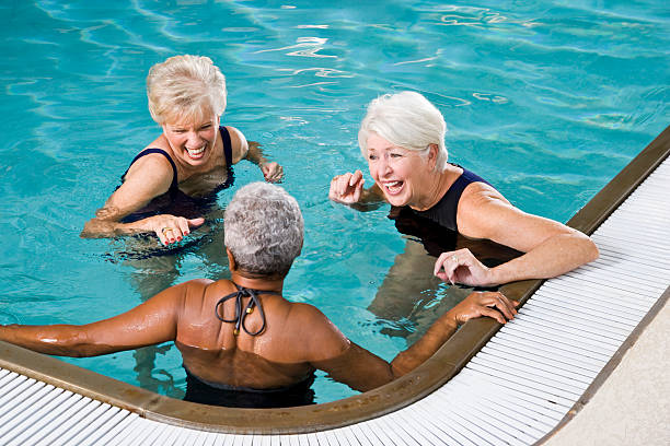 multiraciale femmes âgées rire ensemble dans la piscine - sc0450 photos et images de collection