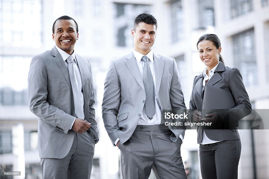 Sorrindo e negócios pessoas em pé do lado de fora. - Foto de stock de Afro-americano royalty-free