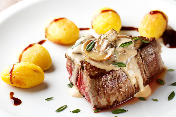 rinderfilet mit sauce aus pilzen und bratkartoffeln - steak filet mignon gourmet fillet stock-fotos und bilder