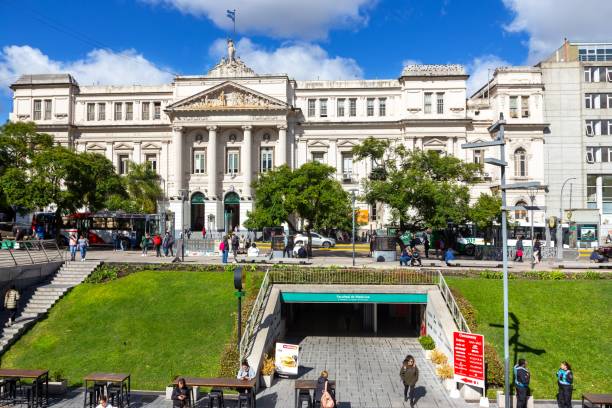 Buenos Aires, Argentina - April 17, 2023:  Students walking in front of Faculty of Economic Sciences ('Economicas') White Neoclassical Building on Avenida Cordoba in City Center
