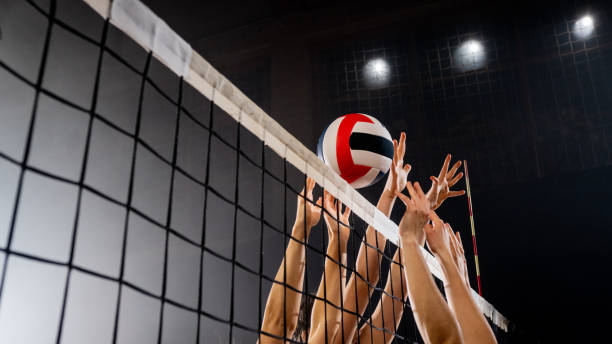 manos femeninas bloqueando pelota de voleibol - pelota de vóleibol fotografías e imágenes de stock