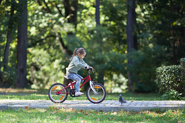 petite fille équitation de vélo - child bicycle cycling danger photos et images de collection