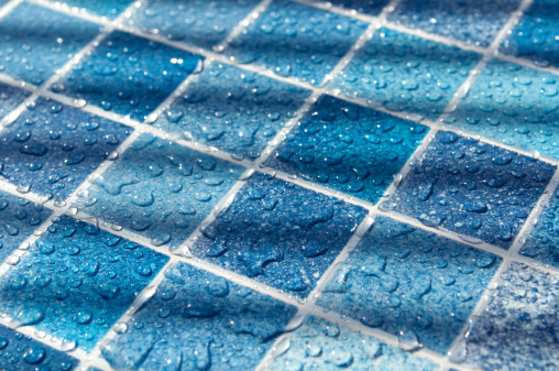 Blue Tiles in Swimming Pool With Water Drops in Sunlight
