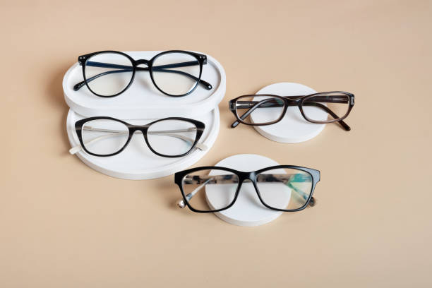 istock Podiums with eyeglasses on colored background. Optical store, vision test, stylish glasses concept top view, flat lay 1582275302