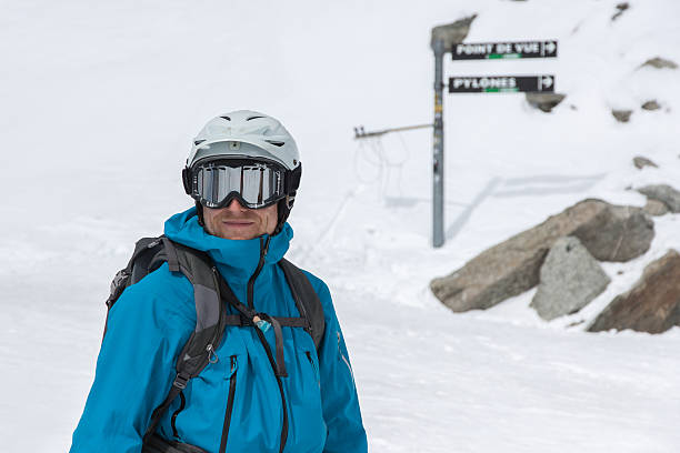 Man in ski gear at top of slope stock photo