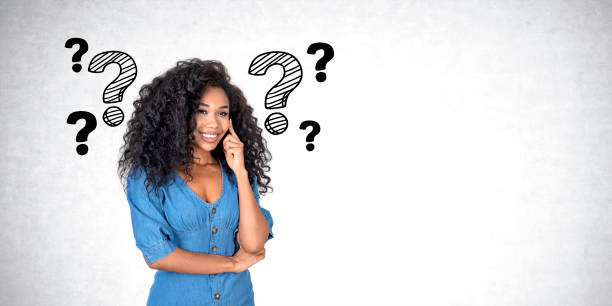 istock African woman with smiling look, question marks on empty grey wall 1582280129