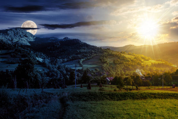 istock summer rural landscape with sun and moon at twilight 1582290304
