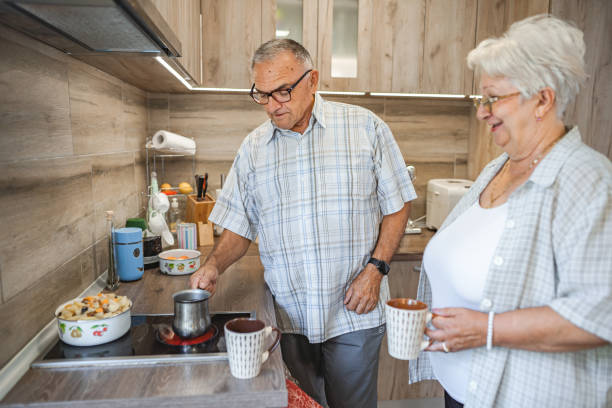 istock Senior married couple making coffee together in the kitchen 1582293664