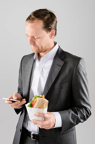 istock Frowning business man with lunch and mobile phone 158232599