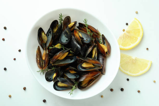 istock Plate with fresh mussels on white background 1582326528