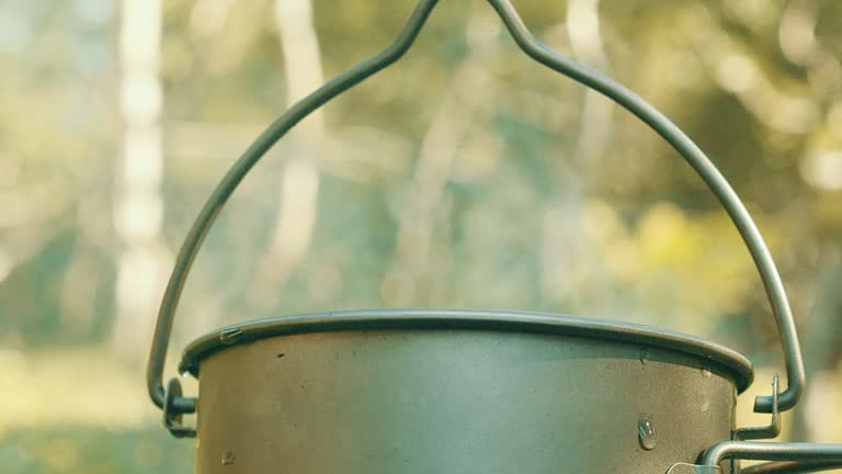 Boiling water in a mug on a fire