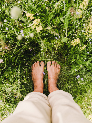 barefoot feet grounding in summer grass outdoors in nature