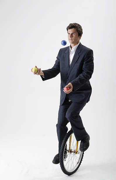 жонглирование бизнесмен на моноцикл - juggling business businessman ball стоковые фото и изображения