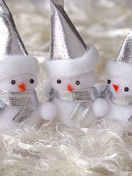 three snowmans with pointed hat stock photo
