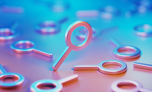 Metallic magnifier symbols illuminated by blue and pink lights on blue and pink background. Horizontal composition with copy space.