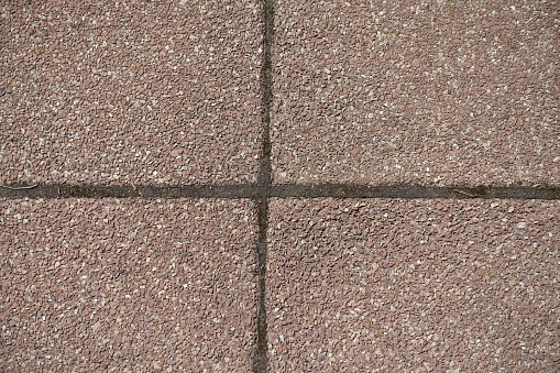 Close view of pavement made of pink tiles of resin bound gravel