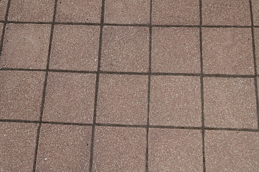 Surface of pavement made of pink tiles of resin bound gravel