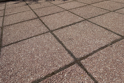 Rough surface of pavement made of pink tiles of resin bound gravel