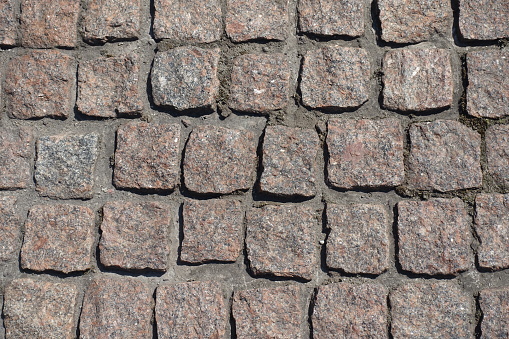 Closeup of pavement made of rectangular pink granite stone setts