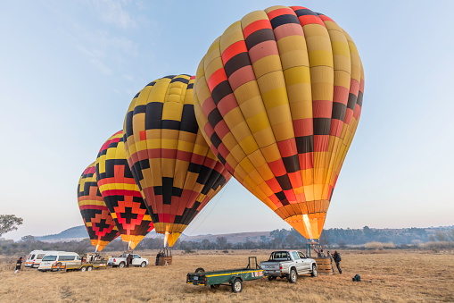 Green hot air balloon with the rock formations in the background flying over Cappadocia Turkey