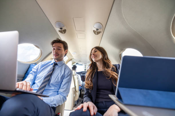 istock Young business couple working on digital tablet in a private jet plane 1582442530