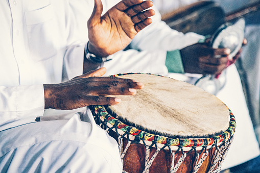 Hands of Moroccan band drummer hitting drums, Merzouga.