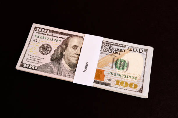 istock A stack of 100 dollar bills with the inscription bonus on a black background. 1582458200