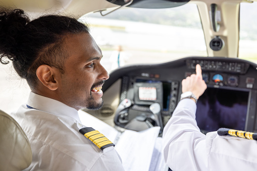 Males pilots preparing private jet for flight