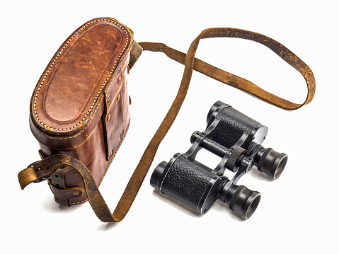 Old antique binoculars and its brown leather bag cover isolated over white background