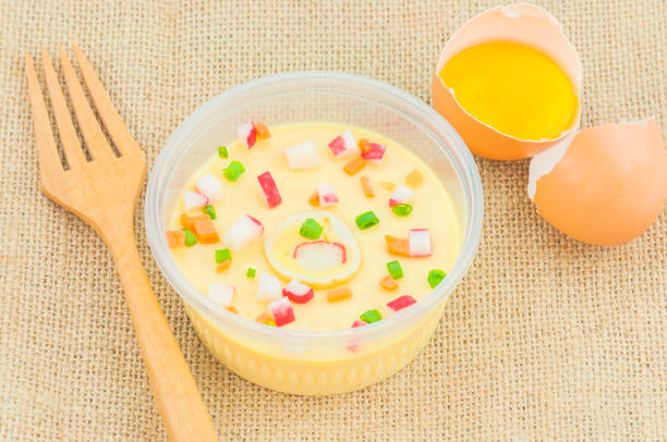 Thai steamed egg with fresh beaten egg and fork decoration on sack background