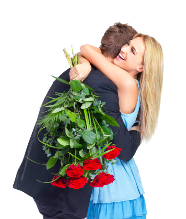 Cute young woman embracing her boyfriend after receiving a bunch of roses - isolated on white