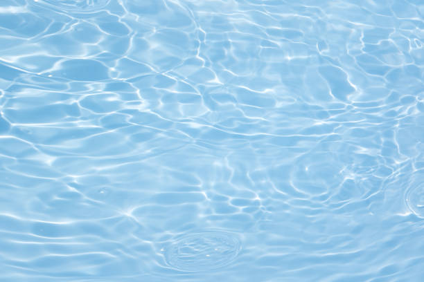 istock Blue water with ripples on the surface. Defocus blurred transparent blue colored clear calm water surface texture with splashes and bubbles. Water waves with shining pattern texture background. 1582527952