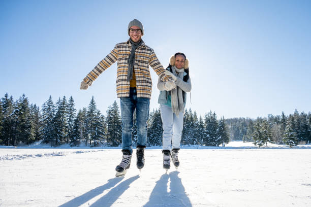 istock Couple ice skating on frozen lake 1582530662