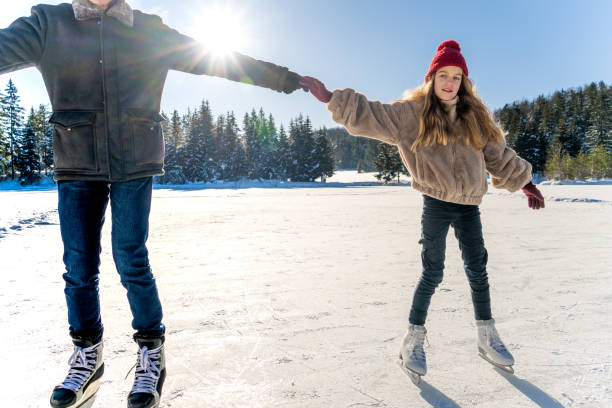 abuelo y nieta patinando sobre hielo en el lago - coat grandfather grandchild granddaughter fotografías e imágenes de stock