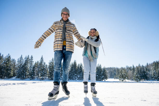 istock Couple ice skating on frozen lake 1582554419