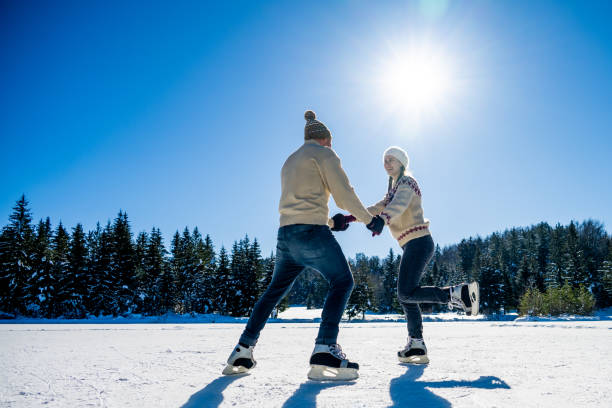 istock Couple ice skating on frozen lake 1582556012