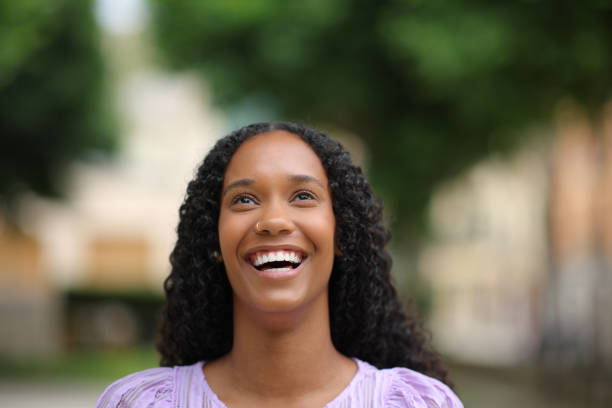 istock Black woman laughing looking up with white teeth 1582559440