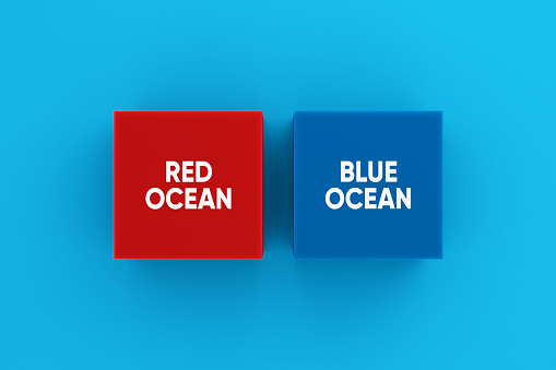 Red ocean and blue ocean business marketing strategy concept. The words red and blue ocean on colorful blocks.