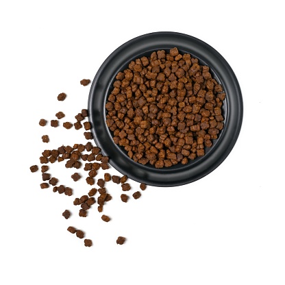 Black feeding bowl with dog or cat kibble seen directly above. Isolated on a white background.