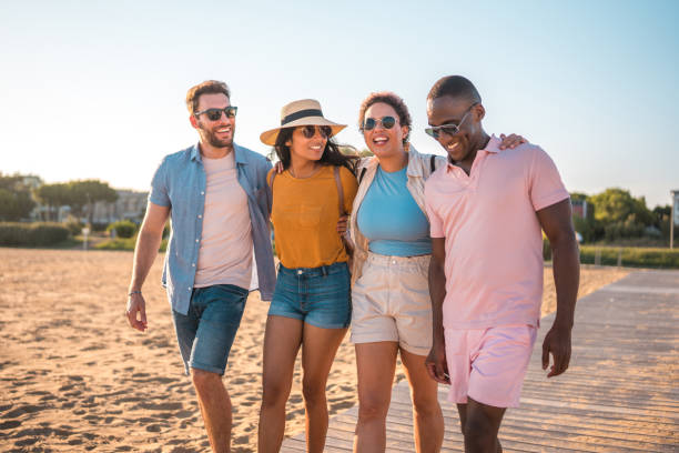 istock Joyful Multiracial Couples Heading to the Beach for Summer Fun 1582603751