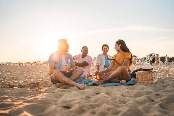 istock Diverse People Eating Snacks and Drinking Beer at the Beach 1582605238