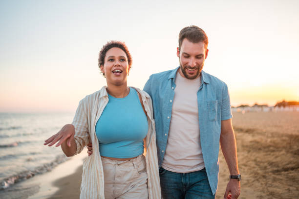 istock Diverse Mid Adult Couple Enjoying a Beach Walk 1582608897