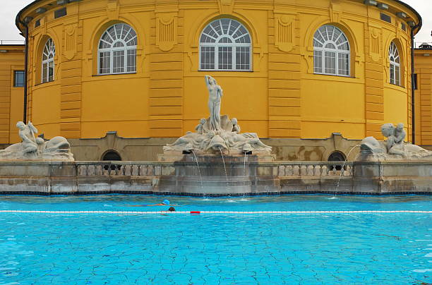 Thermal baths in Budapest Vintage Széchenyi Thermal Bath in Budapest with a fountain and swimming pool thermal pool stock pictures, royalty-free photos & images