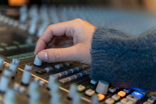 Detail of macro shot of a hand in a control panel of a music recording studio