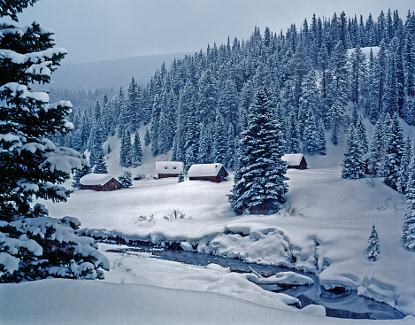 Snowy log cabin village of Dunton in the moonlight, on the West Fork of Dolores River in San Juan National Forest.