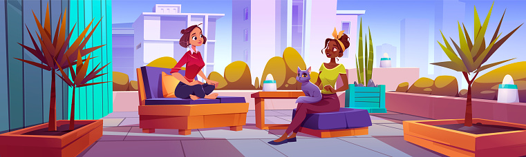 Two women talking on terrace in big city. Vector cartoon illustration of female friends sitting on chairs with cat on lap, urban apartment balcony with cozy furniture and lamps. Cityscape background