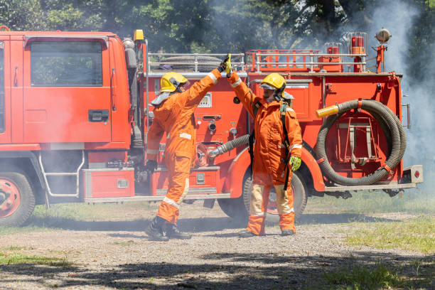 istock Firefighters wearing helmets with fire safety equipment Use Twirl aerosol fire extinguishers to fight oil flames.Preventing fire accidents is an industrial safety concept. 1582656121