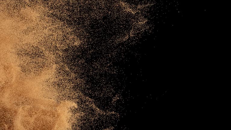 Bronze particles fly on a black background. The wind blows away colored sand. Powder. Spray. Texture. 3d animation.